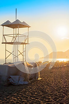 Rescue lifeguard tower by sea ocean sandy beach at sunset