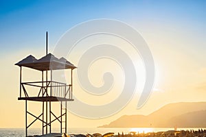 Rescue lifeguard tower sea ocean sandy beach at sunset in evening