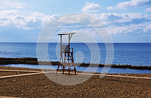 Rescue post on beach on background of sea with blue sky