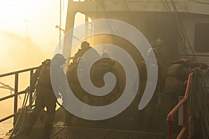 rescue team boarding a smoky, evacuated ship