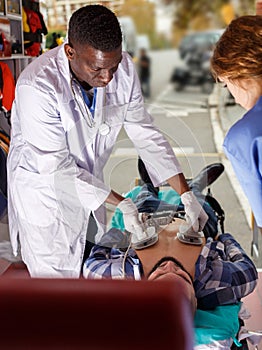 Rescue team making defibrillation to patient