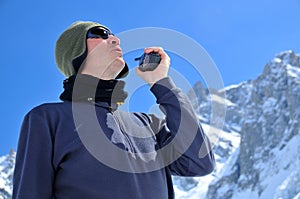 Rescue team member in mountains with walkie talkie