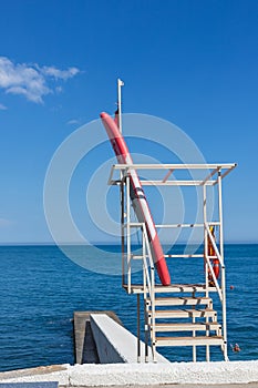 Rescue tower and boat on the pier. view of the sea coast, city beach. Vertical