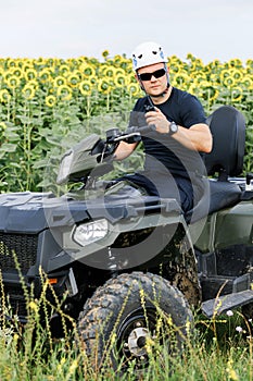 The rescuer, a beautiful athletic physique, rides an ATV in the middle of the field