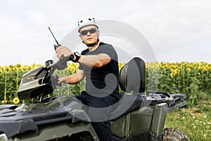 The rescuer, a beautiful athletic physique, rides an ATV in the middle of the field