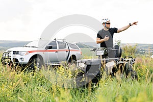 The rescuer, a beautiful athletic physique, rides an ATV in the middle of the field