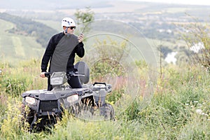 The rescuer, a beautiful athletic physique, rides an ATV in the middle of the field