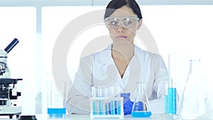 Reseach scientist wearing protective glasses sitting in laboratory