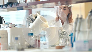 research with liquid nitrogen in the laboratory is carried out by a young female scientist with a protective glass face