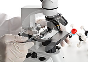 Research scientist working with specimen plate on microscope wit