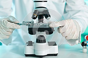 Research scientist working with specimen plate on microscope wit