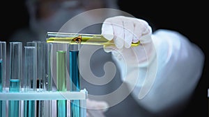 Researcher adding liquid from test tube with fire symbol, warning sign, danger