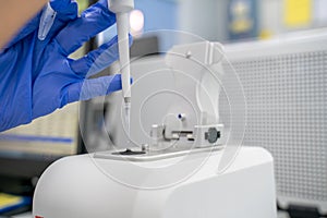 The researcher drops 2 micro-liters of the sample on pedestal to measures the RNA concentration and quality using the Nano Drop