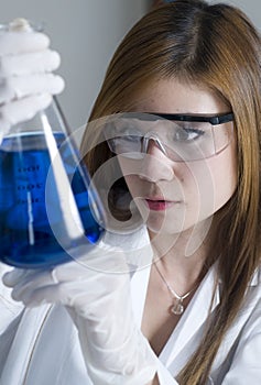 Researcher holding flask with blue chemicals