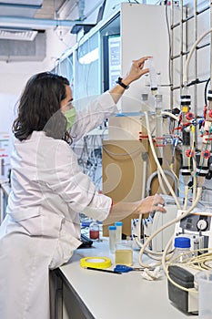 Researcher inoculating a Fluidized Bed Reactor with waste water in a laboratory.