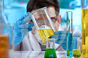 Researcher measuring sample in beaker of liquids in the research lab