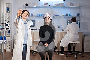 Researcher and patient with eeg headset looking at virtual display