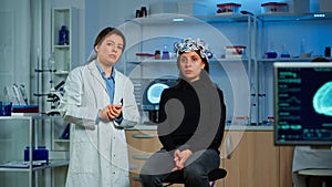 Researcher and patient with eeg headset looking at virtual display