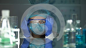 Researcher putting on protective eyeglasses before working with chemical agents