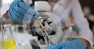 Researcher scientist holds test indicator and lowers test tube