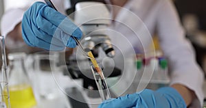 Researcher scientist holds test indicator and lowers test tube