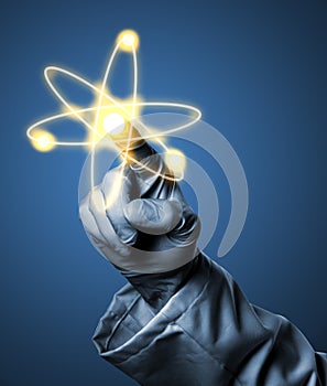 Researcher or scientist with rubber glove holding glowing atom m