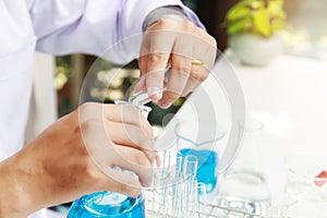 Researcher or scientists loads liquid sample into beaker in laboratory