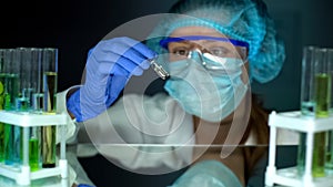 Researcher taking ampule with transparent liquid, antitoxin studies, medication photo