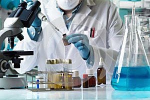 researcher taking reactive with pipette for analysis in the research laboratory