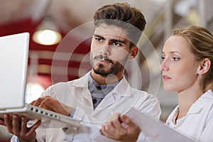 researchers in labcoats checking laptop