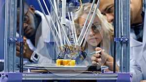 Researchers watching 3-D printing machine in process
