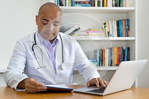Researching medical scientist or doctor with bald working at computer