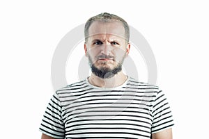 Resentful bearded adult man in a striped T-shirt. 30-35 years old. Isolated on white