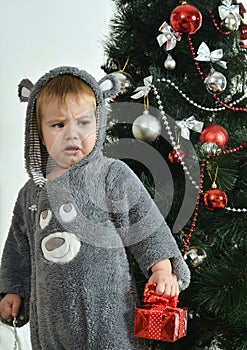 Resentful boy near new-year tree