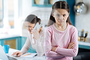 Resentful little girl and her mom working