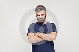 Resentful man, with arms folded, over gray background