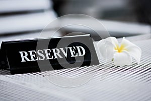 Reserved metal black plate in a restaurant. Reserved metal plate On the white table. vintage photo processing. close up of a