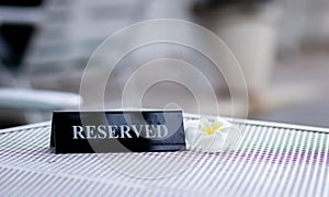Reserved metal black plate in a restaurant. Reserved metal plate On the white table. vintage photo processing. close up of a