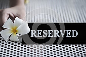 Reserved metal black plate in a restaurant. Reserved metal plate On the white table. vintage photo processing. close up of a