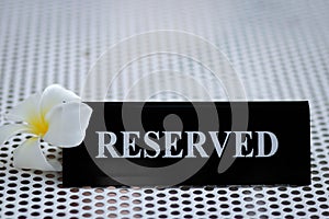 Reserved metal black plate in a restaurant. Reserved metal plate On the white table. vintage photo processing. close up of a