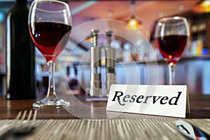 Reserved sign on restaurant table with bar background