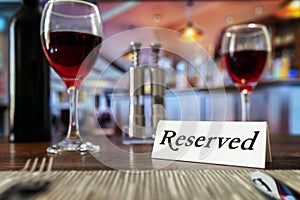 Reserved sign on restaurant table with bar background photo