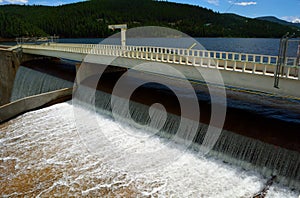 Reservoir Dam Spillway with Water Pouring over the Top in the Mo