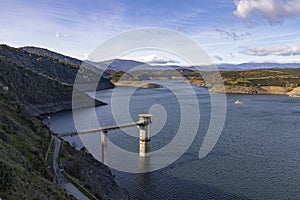 Reservoir. Prey. Dam located in the Atazar, north of the Community of Madrid. Damned water next to some green and pink mountains.