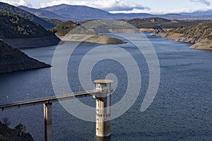 Reservoir. Prey. Dam located in the Atazar, north of the Community of Madrid. Damned water next to some green and pink mountains.