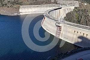 Reservoir. Prey. Dam located in the Atazar, north of the Community of Madrid. Damned water next to some green and pink mountains.