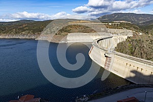 Reservoir. Prey. Dam located in the Atazar, north of the Community of Madrid. Damned water next to some green and pink mountains. photo