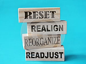 Reset realign readjust, word text written on wooden block, life business term