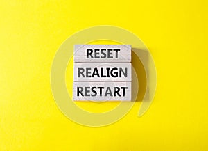 Reset Realign Restart symbol. Concept words Reset Realign Restart on wooden blocks. Beautiful yellow background. Business and photo