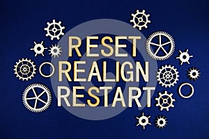 Reset Realign Restart alphabet letters with gears element on navy blue background photo
